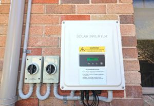 Solar inverter and isolating switches on the side of a house